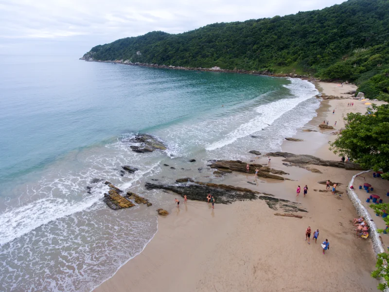 Praia do Retiro dos Padres vista do alto, cercada por costões e vegetação. Acervo de 2018.